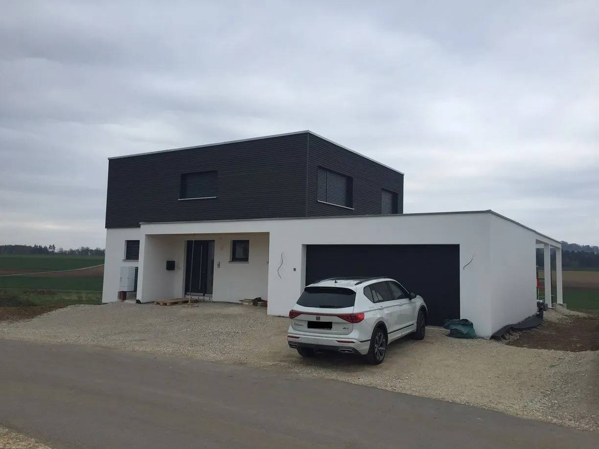 Schlüsselfertig gebautes Einfamilienhaus mit Flachdach, Carport und angelegter Auffahrt