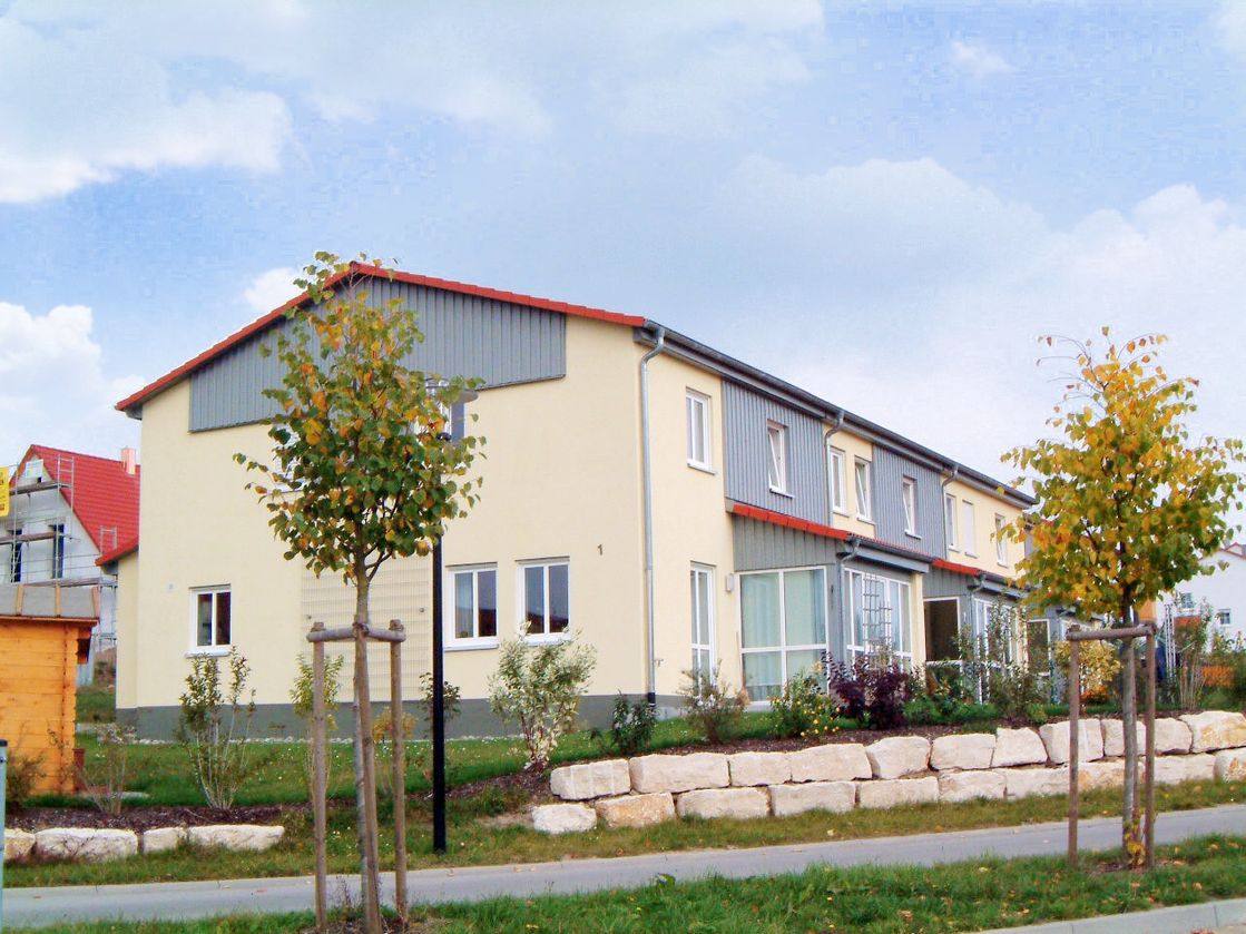 Reihenhauszeile mit einheitlicher Fassadengestaltung und eigenen Hauseingängen